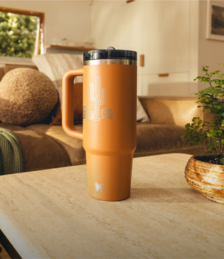 Custom Stanley Tumbler Sitting On Coffee Table With Cactus Engraving