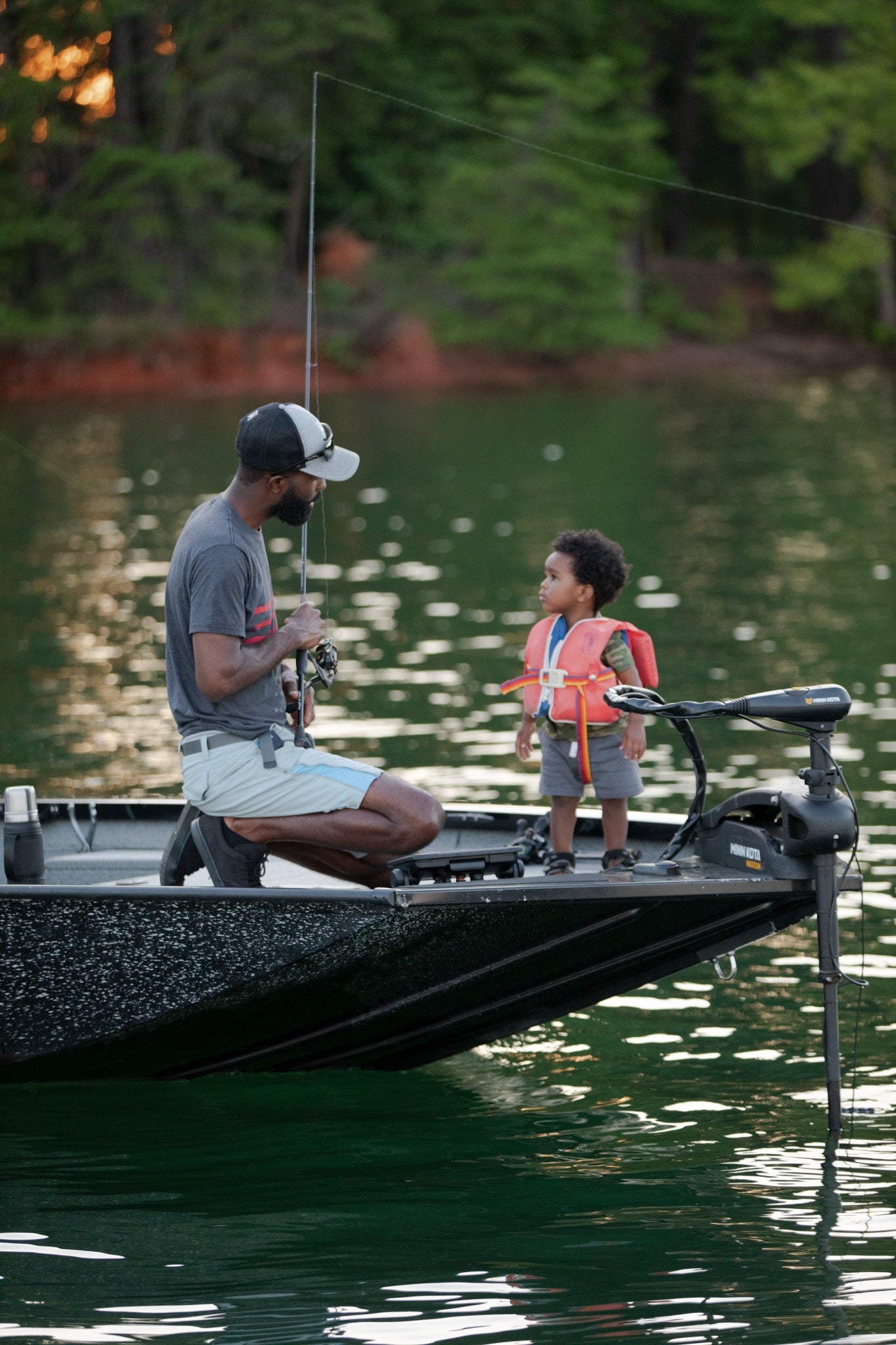 Brian Latimer, Stanley Ambassador and Tournament Bass Fisherman, standing on the bow of his fishing boat on a lake.