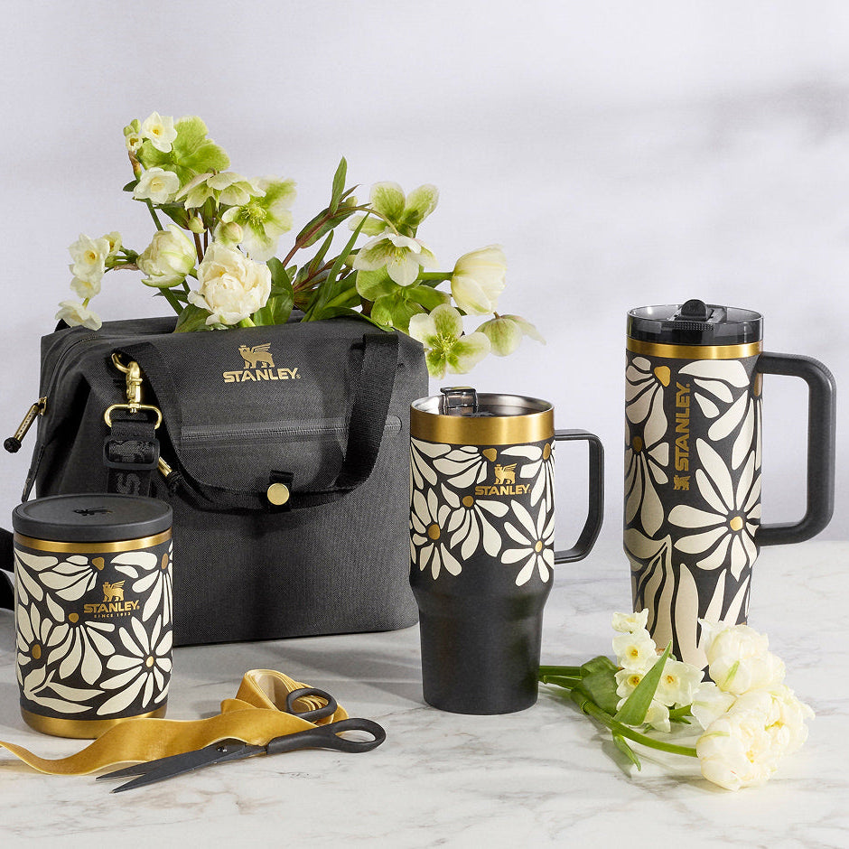 Stanley 1913 Wild Bloom tumblers with floral design on a marble surface with flowers and ribbon.