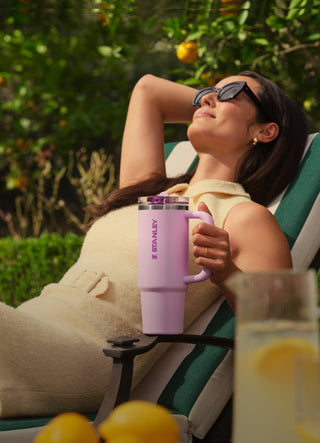 Woman Lounging in Lounger Holding Stanley Quencher
